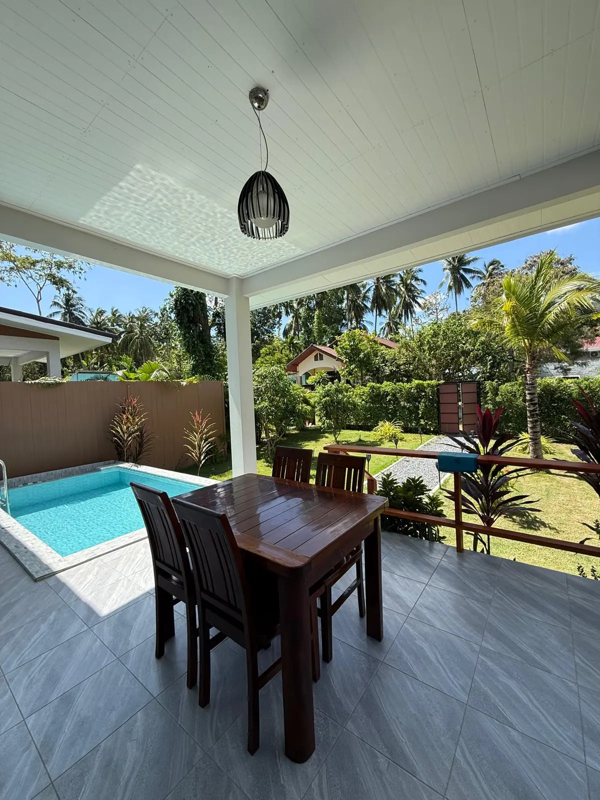 Covered dining terrace beside the private pool and garden