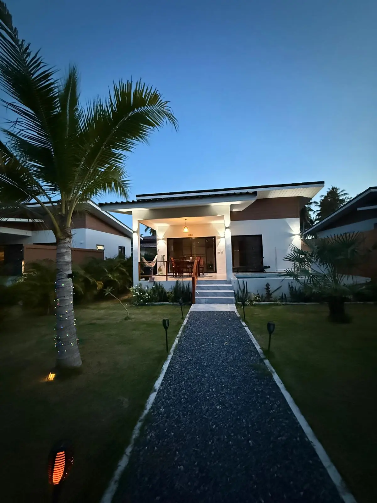 Private Pool Residences villa and garden illuminated at dusk